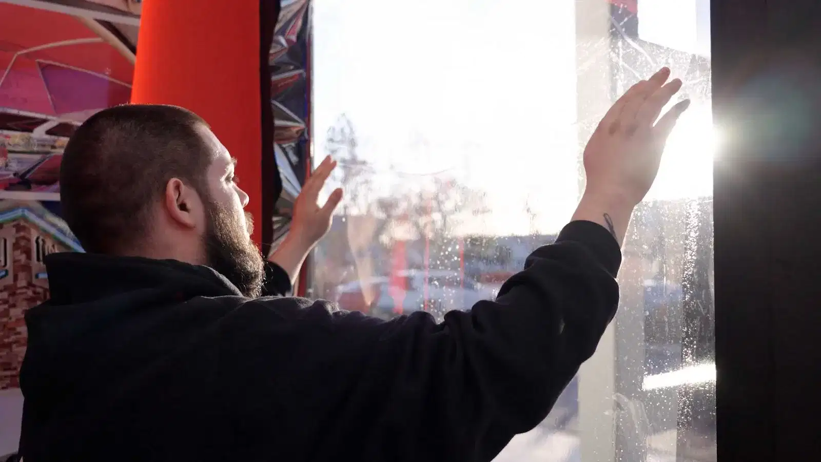 Union installer applying architectural window film inside a home with sunlight through the glass