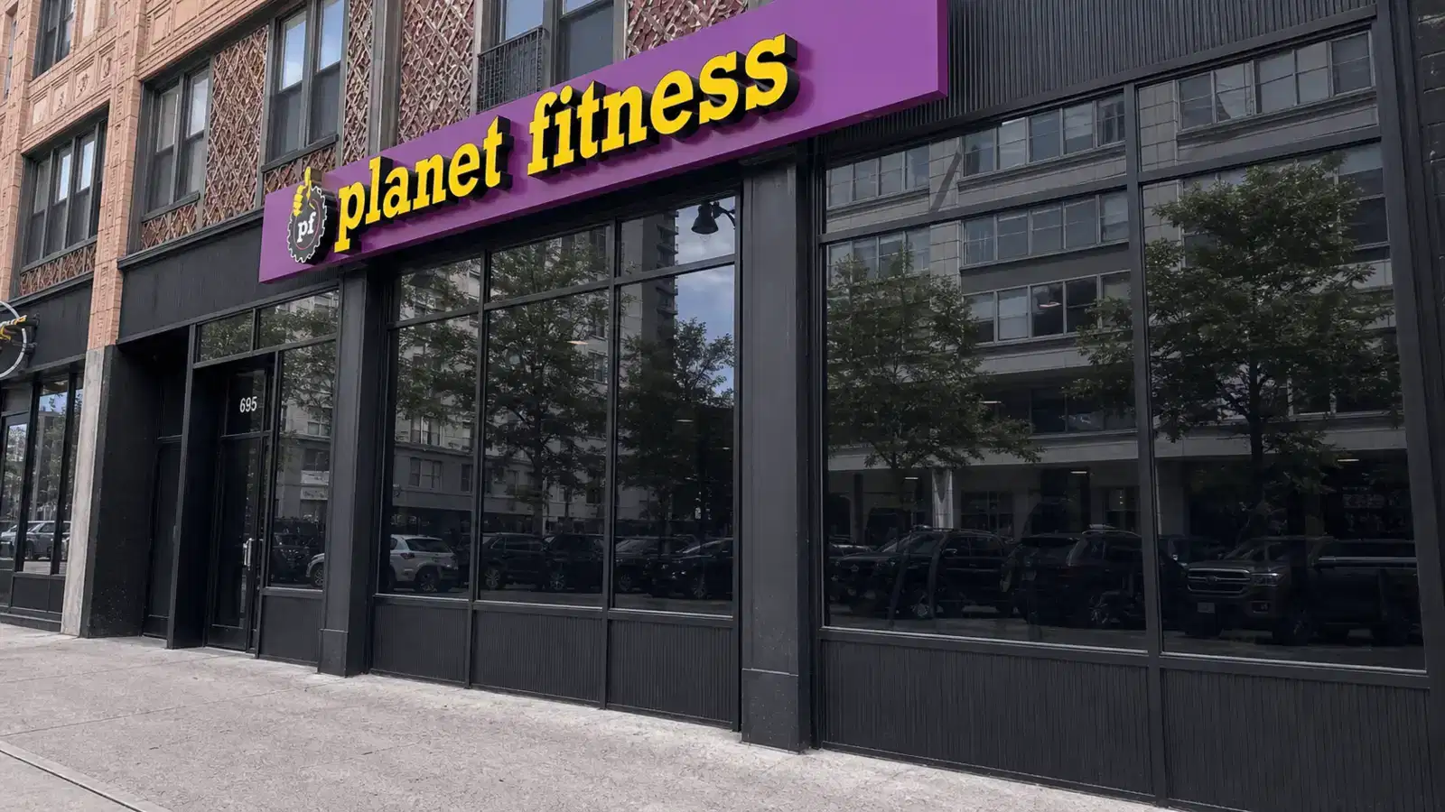 Angled Planet Fitness storefront with dark architectural window film