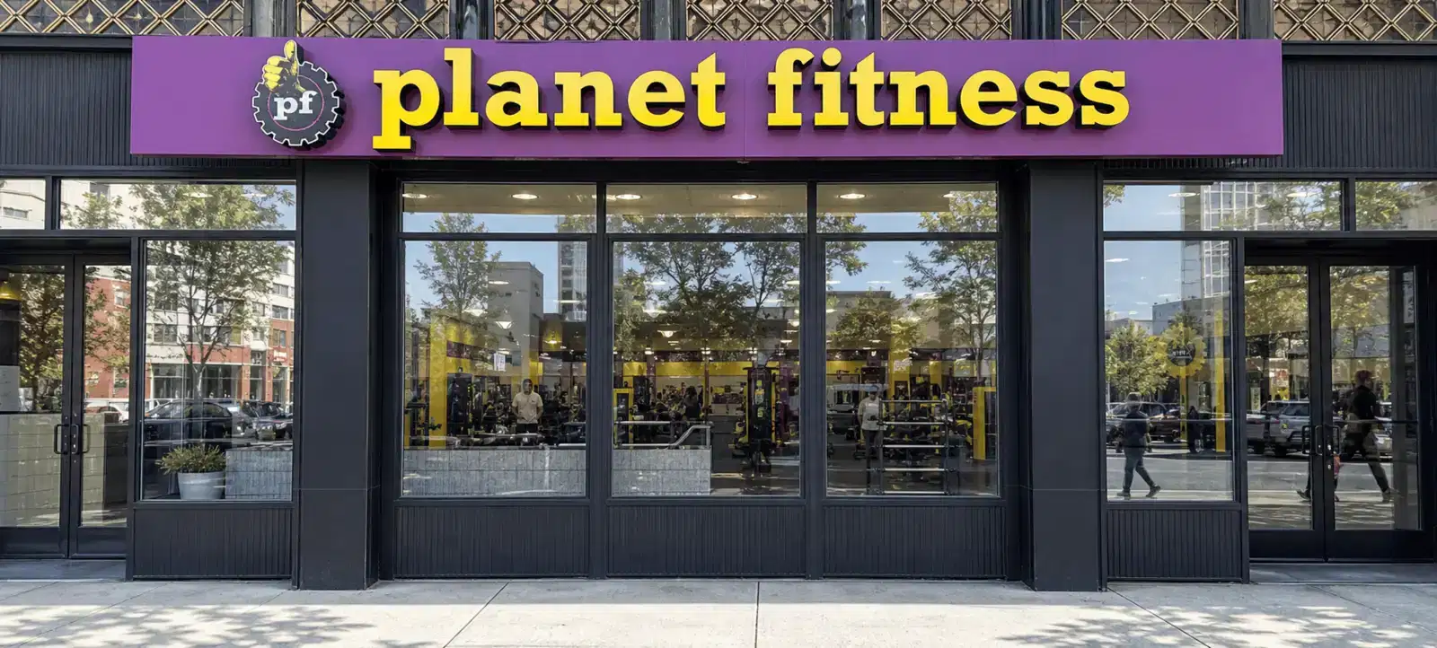 Planet Fitness storefront with architectural window film and visible gym interior