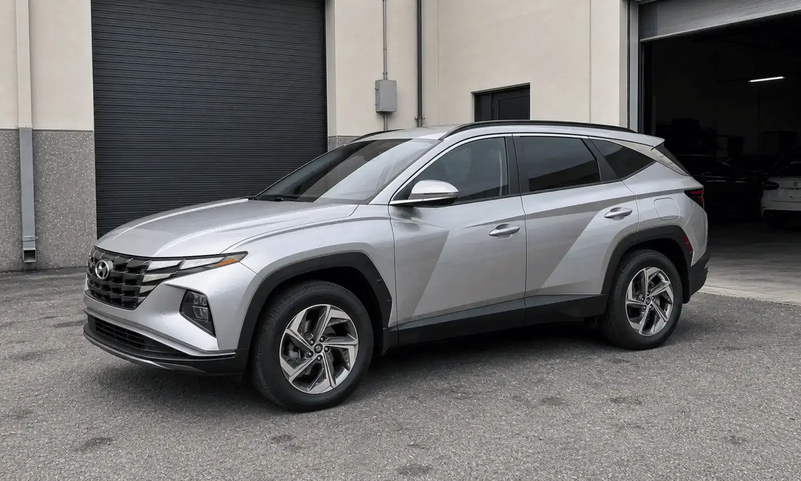 Silver Hyundai Tucson with tinted windows outside a tint workshop