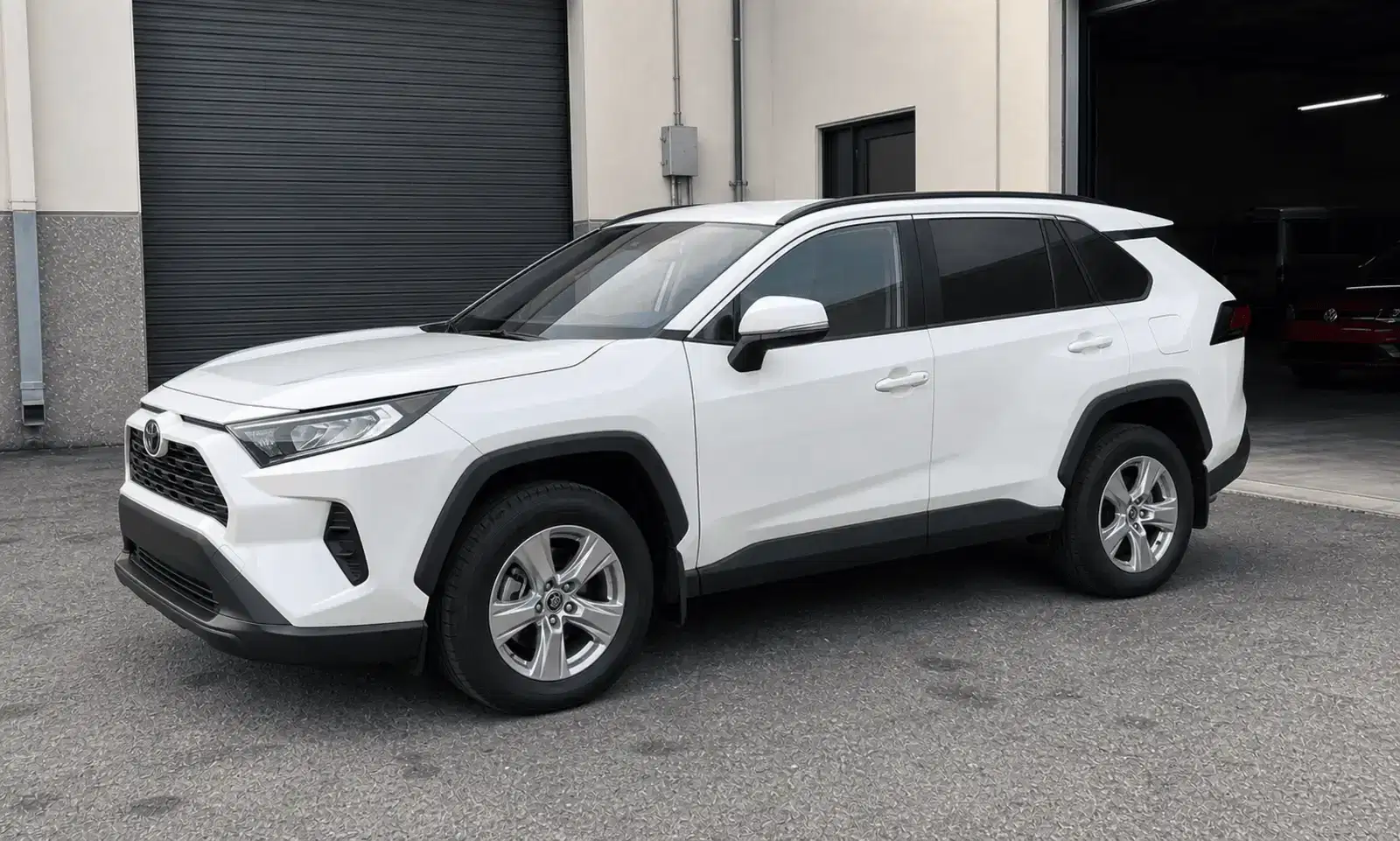 White Toyota RAV4 with rear privacy tint outside a tint workshop